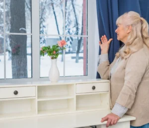 Homeowner enjoying clear winter views through freshly cleaned residential windows, highlighting the benefits of professional winter window cleaning.