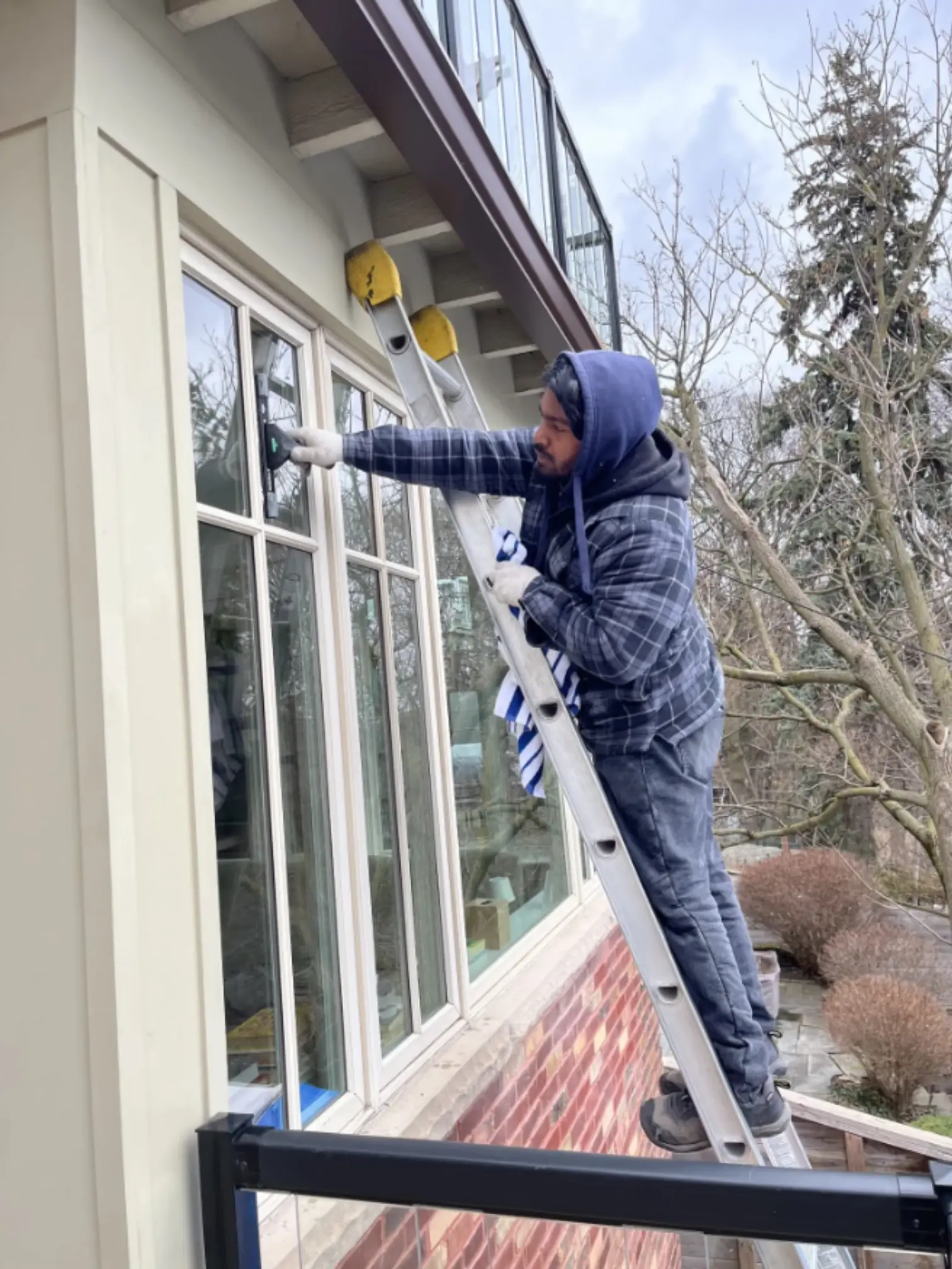 Residential window cleaning on ladder