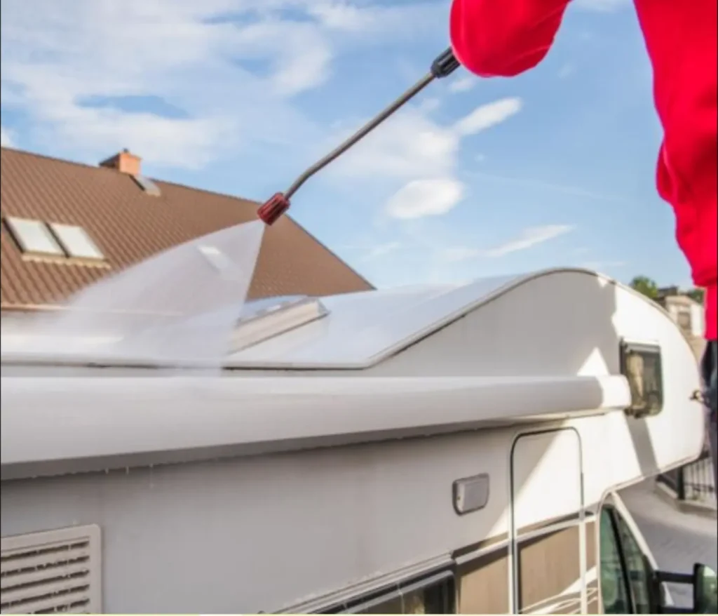 Pressure washing a gutter and roof edge to remove dirt, debris, and buildup, highlighting the need for immediate gutter cleaning and maintenance.